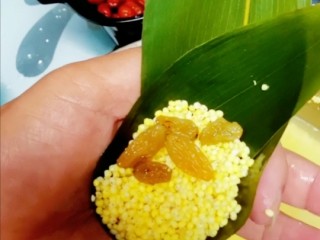 4、红枣花生葡萄干粽子,在放上大黄米，加入葡萄干