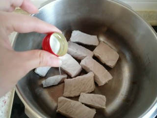 4、自制海苔肉松,把焯好水的里脊放入高压锅 倒一小瓶盖白酒（没有料酒了 就用白酒代替了）。