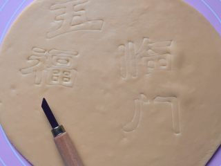8、五福灯笼,然后取黄色面团擀成1cm厚的面片，用美工刀轻轻地刻写出“五 福 临 门”4个字。