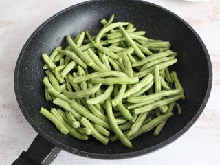 5、酱香干煸豆角,放入豆角，不停煸炒。