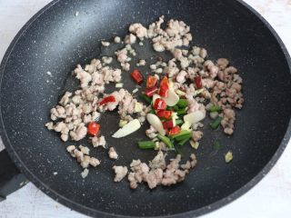 8、酱香干煸豆角,肉末变色后，放入葱、姜、蒜、干辣椒、花椒进行翻炒。