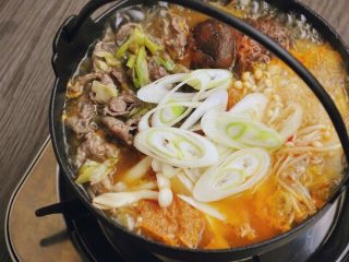 3、韩式菌菇肥牛暖锅,沸腾后加入先前准备好的葱爆肥牛和剩下的大葱，再次沸腾后即可开动！（如果用的是清水，这一步要适当加入盐调味。