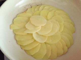 5、培根蘑菇薯片薄饼,刷一层橄榄油,中火热锅,将土豆片铺在锅中(同一个方向扇形铺开)