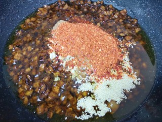 10、香菇牛肉酱,放入熟白芝麻、熟花生碎、五香粉、辣椒粉和冰糖碎，转小火炒至辣椒出红油，冰糖碎融化。