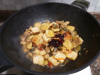 10、酸菜油豆腐烧肥肠,放入一勺老干妈油辣椒翻炒片刻。