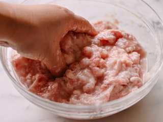 7、东北锅包肉,将猪肉片放入碗中，用手将猪肉完全涂上马铃薯淀粉。