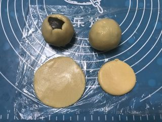 9、广式抹茶蛋黄月饼,取一个面团用手掌摁一下擀成圆形，包上抹茶馅，用虎口慢慢收口