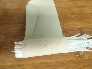 6、金针菇豆皮卷,金针菇洗净沥干后分成一小撮放到豆腐皮上卷起来