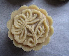 11、广式豆沙月饼,倒扣在铺了油纸的烤盘内,轻轻的压(不用太用力),然后脱模