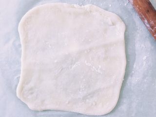 15、抹茶白玉卷,把卷皮放在油纸上,表面也洒少量的玉米淀粉防止过粘,用擀面杖擀成长方形,长度约要是要卷蛋糕体长度的5倍