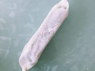 21、抹茶白玉卷,用油纸把卷卷好,封口向下,两端拧紧,放入冰箱冷冻3小时