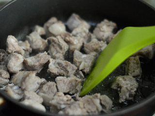 4、可乐排骨,锅里倒入适量油,下排骨翻炒