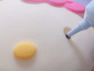 25、家有烤箱+hello kitty可可慕斯(附戚风蛋糕),黑色巧克力笔融化后，在模具眼睛位置挤上，速度要快，不然巧克力很快就遇冷凝固了。