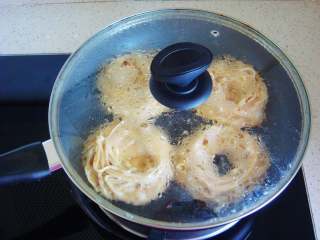 8、鸟巢鸡蛋饼,盖上锅盖，开始煎制。