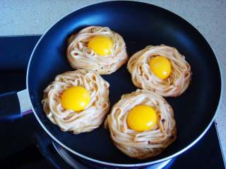 9、鸟巢鸡蛋饼,一分钟后倒入鸡蛋黄，盖上锅盖继续煎。