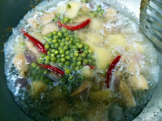 11、土豆炖鸡肉,再倒入事先煮好的青豆。盖上锅盖转小火闷制。