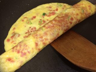 11、火腿葱花厚蛋烧,一定用小火慢煎至9.5分熟，用锅铲慢慢从一边卷向另一边