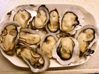 2、蒜蓉蒸生蚝,因为一个盘装不下，我分了两份，先取一半带壳的生蚝摆上盘，另外一半全去壳取肉，用来蒸粉丝。