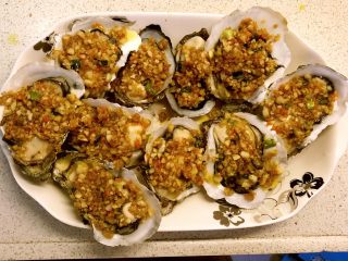 6、蒜蓉蒸生蚝,用小勺均匀舀在生蚝上。