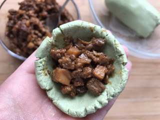 10、酱肉笋丁青团,取一小块面团捏成小碗状，放入前面炒好的肉馅