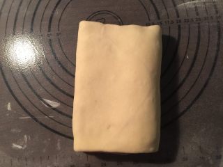 8、流沙起酥包,从面片的一端1/3处把面片向中间翻折，另一端也从1/3处向中间翻折。这是第一次三折；再用擀面杖擀开，重复上面再一次三折。这是第二次三折，把三折好的面片再次放入冰箱冷藏松弛20分钟，重新擀成长方形，再做一次四折
