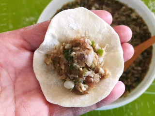 32、冬至美食  黄蘑猪肉馅水饺,取一个饺子皮，加入一勺馅料