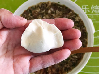 33、冬至美食  黄蘑猪肉馅水饺,用双手捏合在一起，一个水饺就包好了