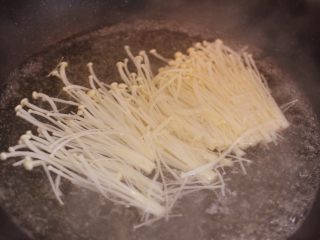 6、金针酸汤肥牛,金针菇放沸水中焯熟。