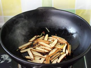 6、做年货-麻辣烫,加入切成片的豆腐干、小火慢慢煎至