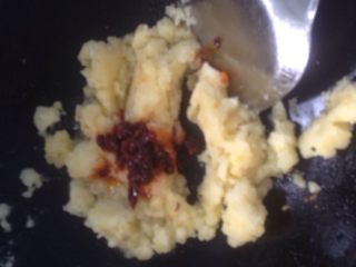 8、土豆泥（三味道）,倒少许油，放土豆泥加辣椒酱，混合均匀炒至起少许锅巴。提示：我没买葱，放些葱花炒更香。
