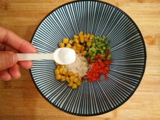 4、什锦蛋黄堡,将黄瓜，胡萝卜，玉米放入容器中，加入适量的盐，鸡精，五香粉。