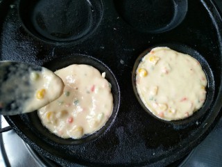 10、什锦蛋黄堡,在蛋饺锅的两个孔中舀进一勺粉糊。