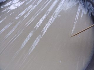 4、广式冰皮蛋黄月饼,过筛完倒入盘中,盖上保鲜膜,用牙签在保鲜膜的面上扎少量的孔。