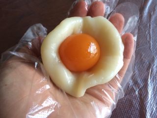 11、广式冰皮蛋黄月饼,揉好的冰皮分成6等份,每份55克,然后全部包入蛋黄。
