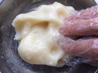 10、广式冰皮蛋黄月饼,这时候冰皮已经蒸熟起锅,把冰皮拿出锅中,稍微放凉不烫手,手带上一次性手套把冰皮揉至光滑。