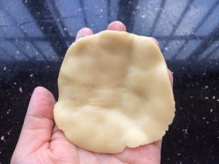 12、广式冰皮蛋黄月饼,松弛好的广式饼皮同样分成6等份,每份30克,把饼皮搓圆放手心中轻轻压成薄饼状。