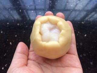 13、广式冰皮蛋黄月饼,再放入包了蛋黄的冰皮,包住收口。