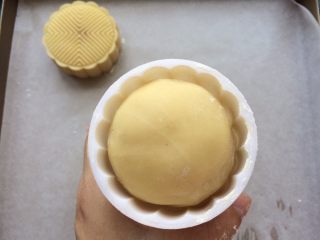 14、广式冰皮蛋黄月饼,模具撒入适量的低粉,抖掉多余的粉,月饼团放入模具中轻轻用手中按压一下底部。