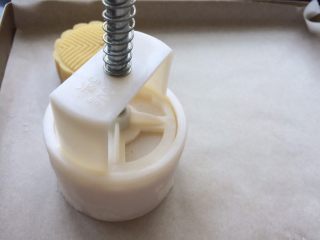 15、广式冰皮蛋黄月饼,然后倒扣在烤盘中,轻轻按压下去,轻轻提起模具推出月饼。