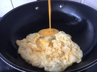 6、#懒人料理# 西红柿炒鸡蛋圆白菜,锅里放适量的油，当油温六、七成热时，把鸡蛋液倒入，炒熟了后盛出来备用。