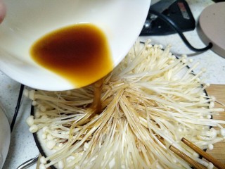 8、最好吃的油泼金针菇,把调好的汁倒在金针菇上。
