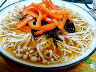 14、最好吃的油泼金针菇,把彩椒丝和木耳摆在金针菇上。