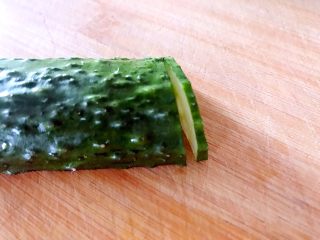 3、喜欢吃黄瓜的人注意了，这种做法让您吃得与众不同,用锋利的小刀从黄瓜尾部开始，切一片，注意不能切断。