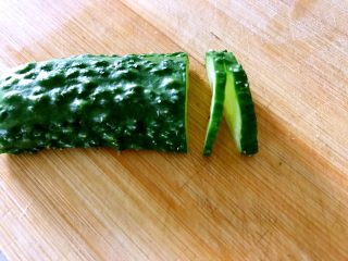 4、喜欢吃黄瓜的人注意了，这种做法让您吃得与众不同,均匀的切二片，第二刀切断。