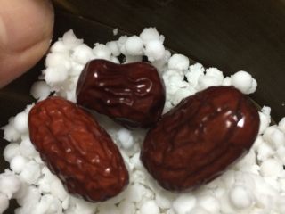 4、红蓝水晶粽子,把粽叶结成漏斗形状，斗尖要结实，要不漏米哦，放西米放进去，用手压实，放红枣，红蓝叶在中间，再放西米上面，再压实，把粽子包好，用绳子扎好