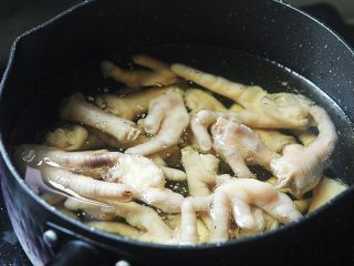 8、早茶必点的菜——虎皮凤爪,等鸡爪晾干后，锅内放入适量油，8成热时放入鸡爪，轻轻搅拌一下不要粘在一起，然后盖盖子，一定要盖盖子，会爆油；