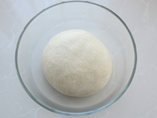 3、热狗面包,把面团整理好放进容器中,覆盖保鲜膜放温暖处发酵