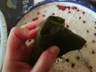 10、红豆粽子,沿着这个角 将粽叶尾巴折向两边。