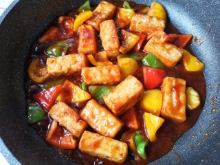 16、咕咾豆腐,中火翻炒均匀，让豆腐和彩椒都裹满料汁即可。