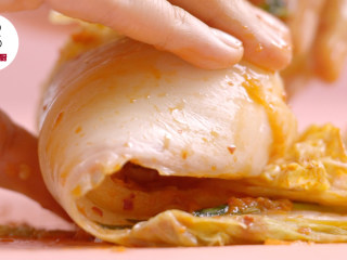 5、3步搞定零失败安心辣白菜,将大白菜由根部开始向内卷起，放入保鲜盒内，将剩余酱料倒入保鲜盒中，密封，室温下放1天自然发酵，再放入冰箱冷藏